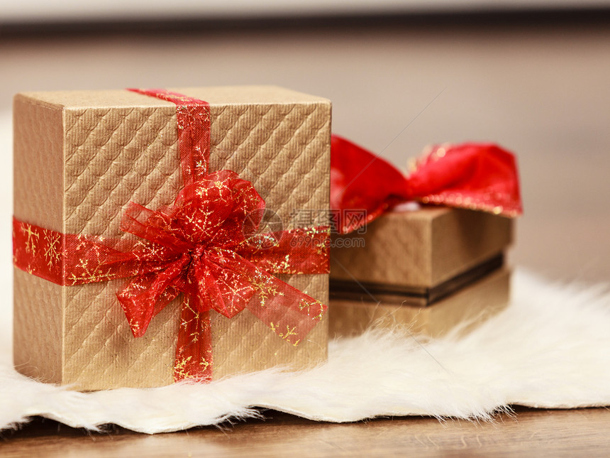 两个带红丝结的金礼物盒圣诞时间概念图片