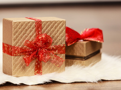 两个带红丝结的金礼物盒圣诞时间概念图片