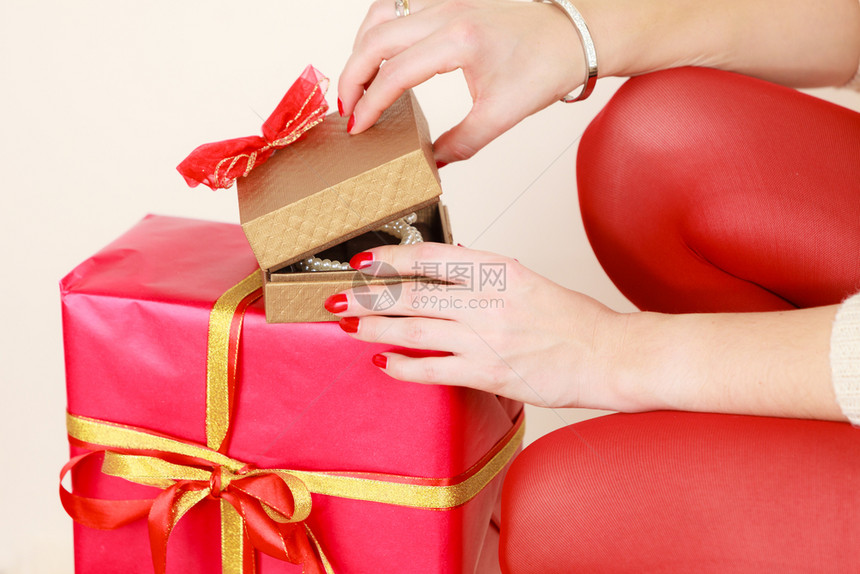 女用红指甲修打开黄金礼物盒配有珠宝珍圣诞节时间赠与和幸福的概念女用珠宝珍打开黄金礼物盒图片