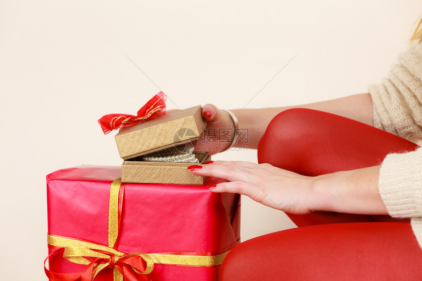 女用红指甲修打开黄金礼物盒配有珠宝珍圣诞节时间赠与和幸福的概念女用珠宝珍打开黄金礼物盒图片