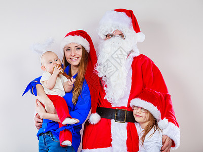 圣诞节家庭概念母亲幼儿婴和穿着圣诞老人服装的男母亲圣诞老人和两个女儿的圣诞节家庭照片背景图片