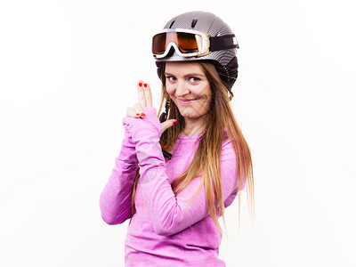 冬季运动爱好者概念戴运动头盔的女人穿粉色衣服的年轻女士图片