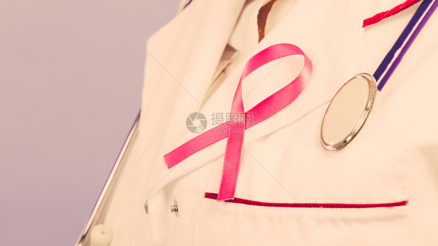 妇女为健康而斗争乳腺癌肿瘤概念白色医疗围裙制服上的粉色丝带和蓝听诊器穿医疗制服的粉色丝带和听诊器图片