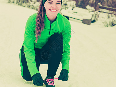 冬季体育活动健康生方式概念合适的女运动员在寒冷的雪天气中穿着温暖运动服在户外训练身着温暖运动服的合适女员陶美形象冷天在户外训练适背景