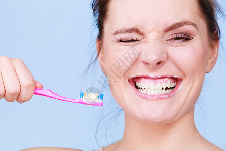 妇女刷牙口腔卫生蓝背景背景图片