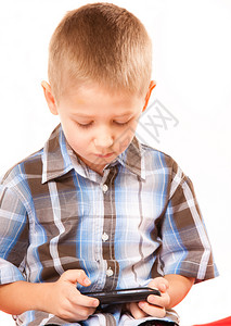休闲技术和互联网概念有智能电话游戏或阅读短信的小男孩图片