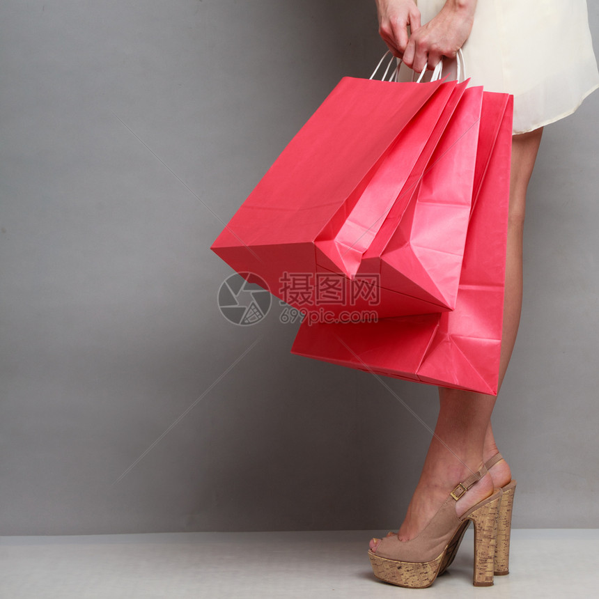 持有红纸购物袋的女人高雅士光亮裙子买衣服销售和零图片