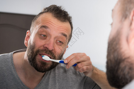 照顾口腔卫生清晨洗手间例行工作时刷牙的人在洗手间刷牙图片