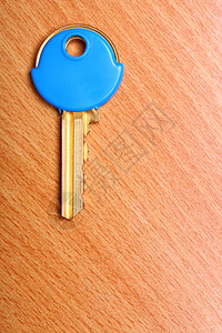 木桌背景上有蓝色塑料大衣盖的房子钥匙图片