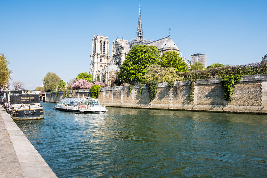 法国巴黎2019年4月3日巴黎塞纳河水边和巴黎诺尔大坝的旅游轮也称为巴黎圣母诺尔大坝中世纪哥斯教堂建筑和河船观光巴黎塞纳河水边和图片