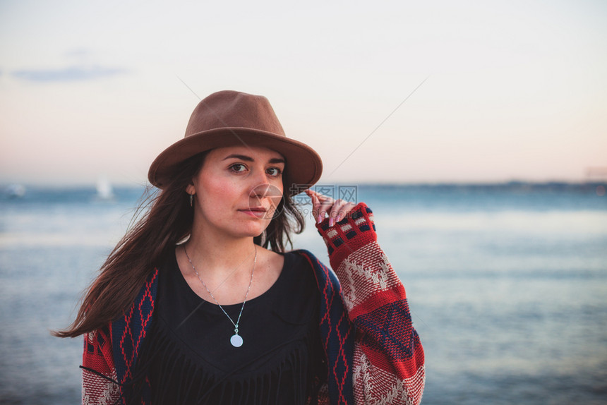 穿旅行服装和戴帽子的妇女跨越海洋和天空背景旅行概念照片图片