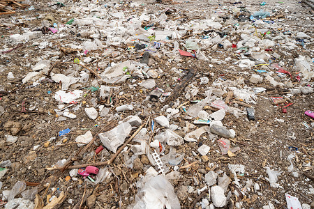 在环境污染概念中在城市一堵墙附近存放各种不同类型的大垃圾堆塑料袋和垃圾桶背景图片