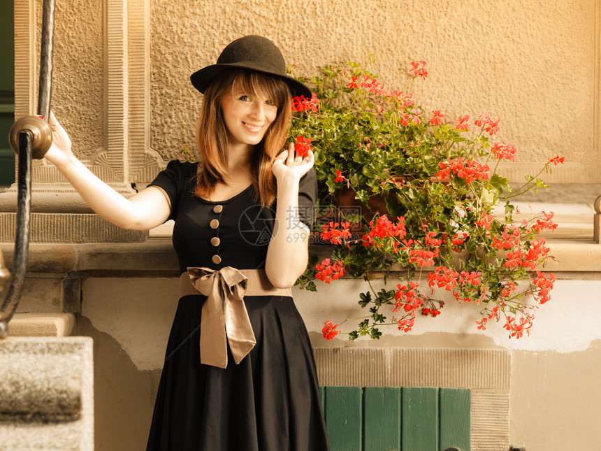 穿黑帽子的女时装郎穿着黑帽子的时装女郎在旧城波兰格丹斯克泽街上穿着衣服图片