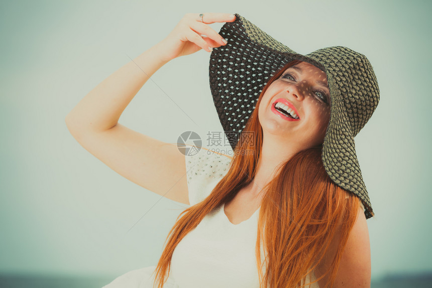 穿着大黑太阳帽的红发妇女快乐图片