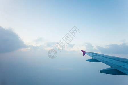 从空中的飞机窗口看到云和翼图片