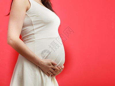 孕妇露出肚子在红色背景上图片