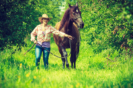 西方妇女骑马在绿草地或森林上行走西方妇女骑马在绿草地上行走图片