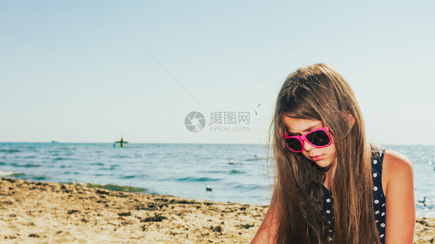 可爱的小女孩穿着暑期服在外面海边玩得开心小孩在海边玩耍图片