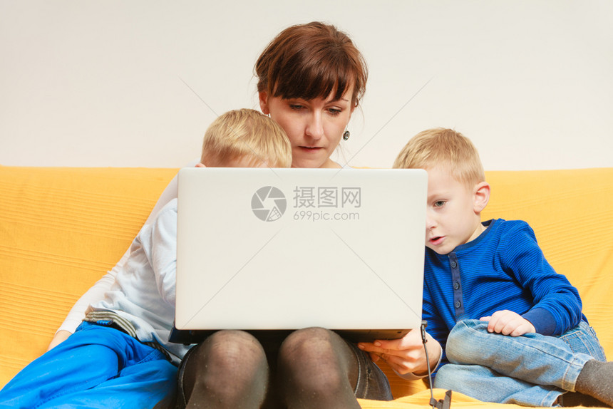 乐两个小男孩和母亲使用笔记本电脑图片