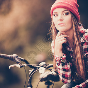 美丽的女子在公园骑自行车休息图片