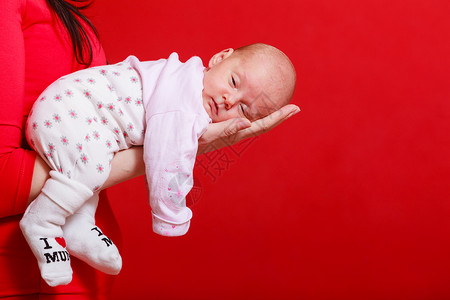 幼童无罪概念小可爱的新生婴儿躺在母亲的手上红色背景小新生婴儿躺在母亲的手上背景图片
