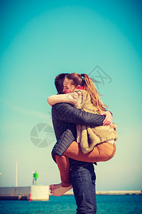 幸福的情侣在海边滩上约会男人抱着女幸福的情侣在海滩上约会图片