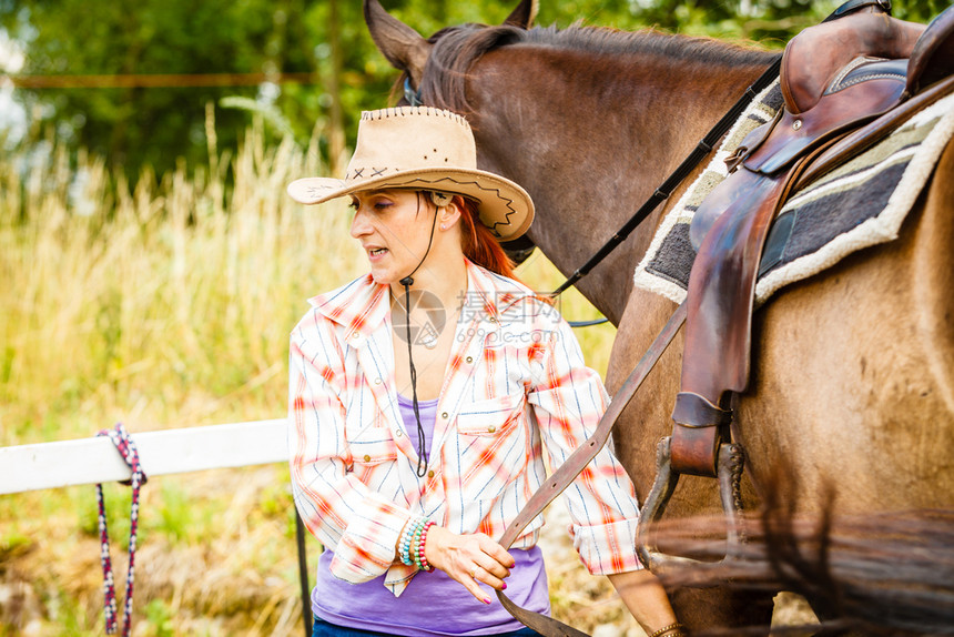 牛仔女孩在农村准备骑马牛仔女孩在农村准备骑马图片