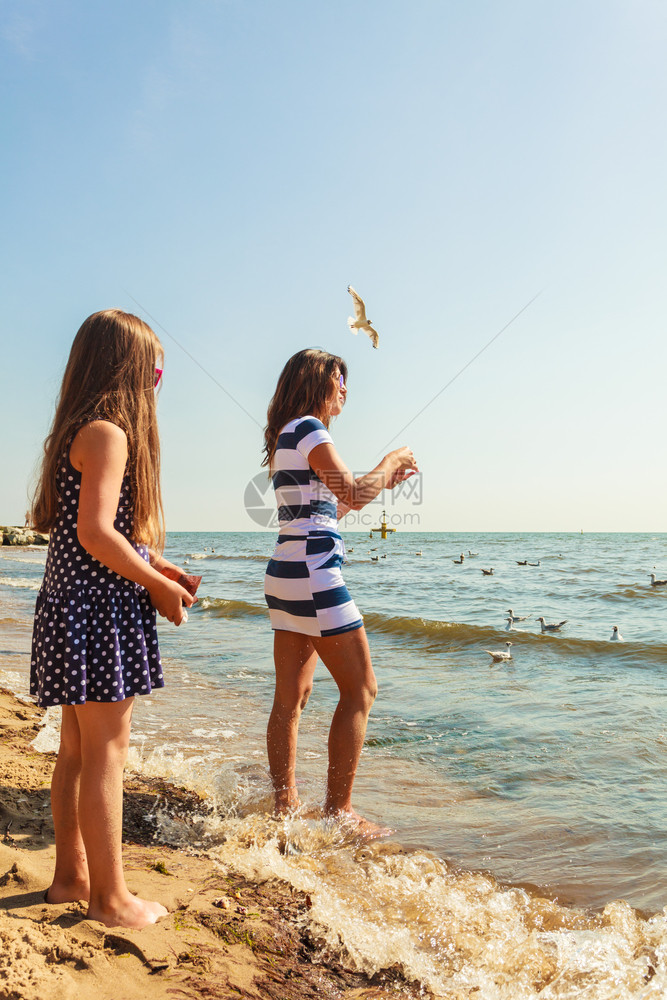 夏天玩得开心可爱的女孩儿和妈玩得开心家人一起在海边玩母亲和女儿在海滩玩图片