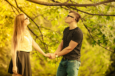 情侣在公园里女孩和男在树下牵手图片