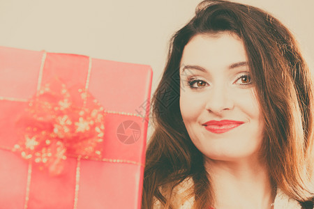 拿着红礼盒的漂亮女人圣诞节庆祝的概念红礼盒女人图片