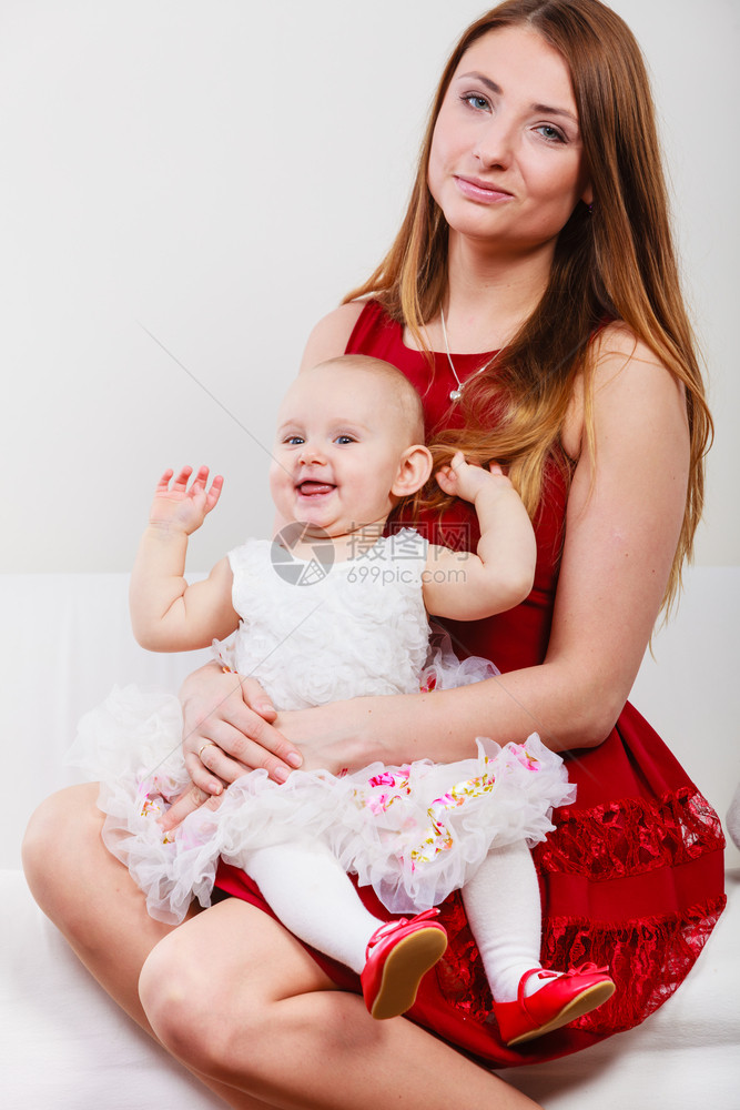 年轻优雅的母亲穿着芭蕾舞公主礼服的女婴跪在妈的膝盖上图片