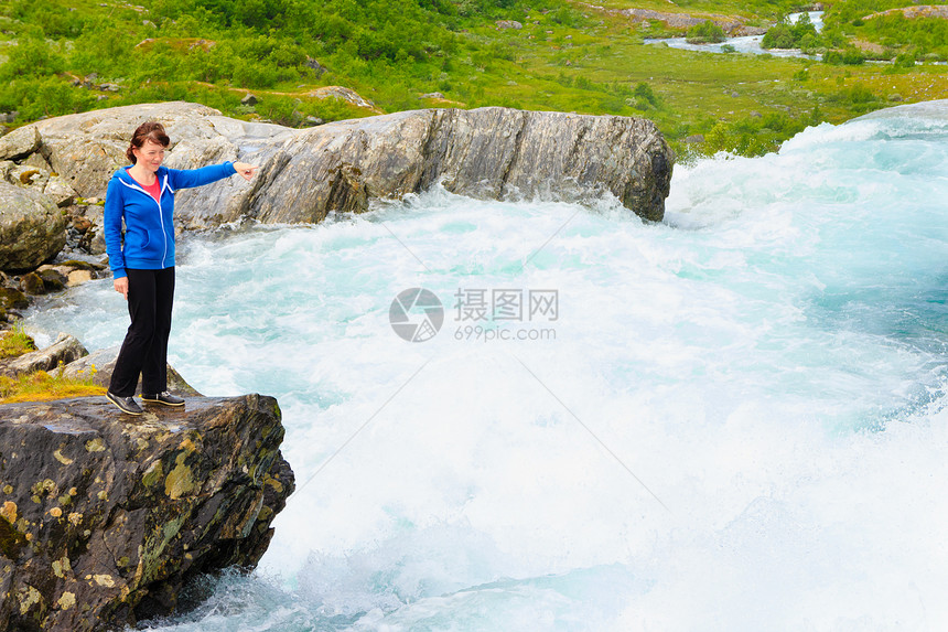 旅行自然美的丽旅游女在挪威观看Videfossen称为Buldrefossen瀑布图片