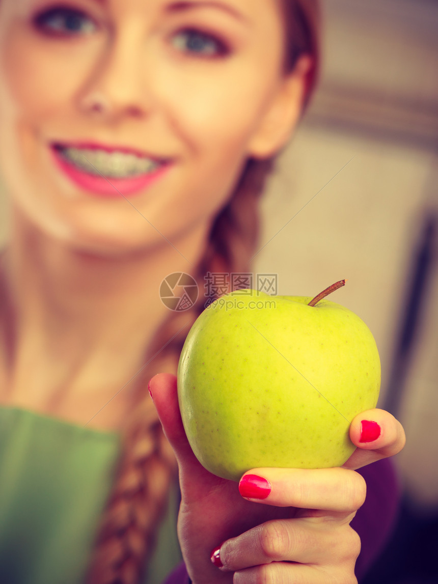 长头发的女青年子持有大绿色黄苹果水健康饮食素和人的概念图片