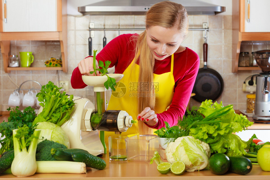 厨房里的年轻女用绿色蔬菜制成健康的蔬菜冰淇淋汁厨房里的女用蔬菜汁制成冰淇淋汁图片