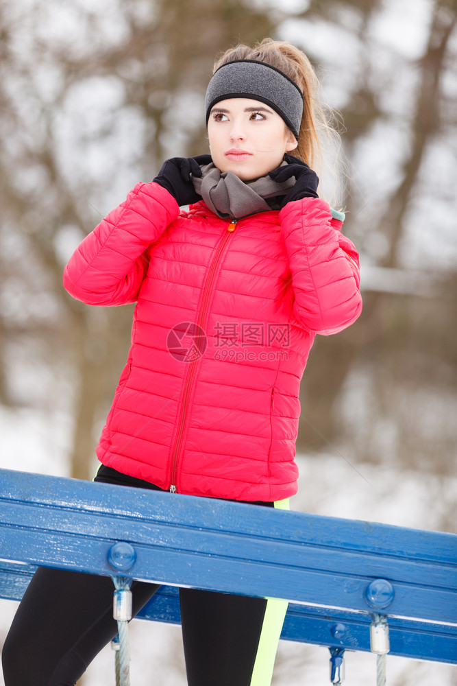 穿着温暖运动服的女在前准备就绪在冬季跑步到外面图片
