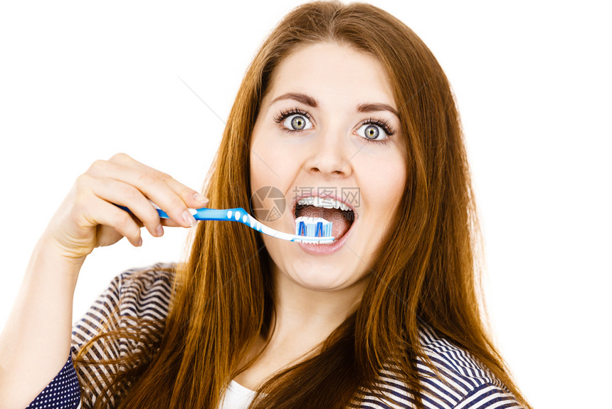 穿着睡衣的妇女拿有糊的牙刷微笑着正女孩准备打扫牙齿口腔卫生孤立在白色上女人拿着有糊的牙刷图片