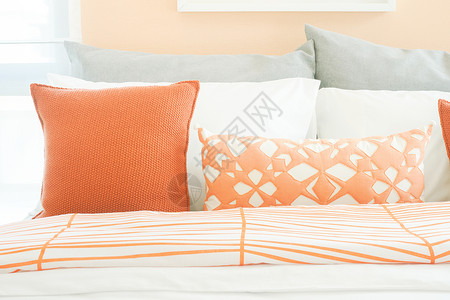 床上橙色和灰的闭合枕头高清图片