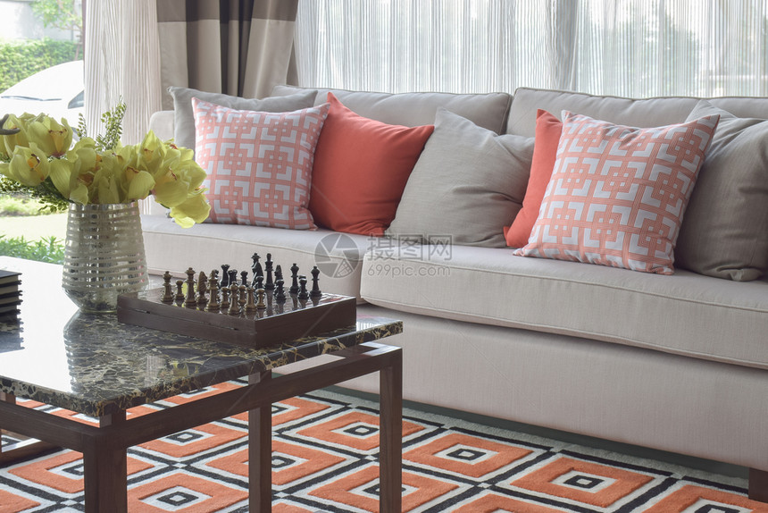 客厅的图形橙色计划枕头和图形橙色地毯图片