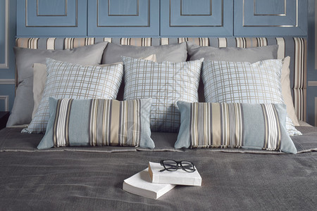 卧室灰色以浪漫的浅蓝色床铺风格写有图案和纹身枕头的书背景