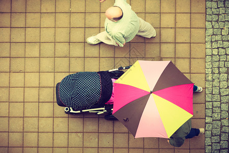 无法辨认的人用紫色雨伞在城市街上行走的顶端视图观众用雨伞在街上行走背景图片