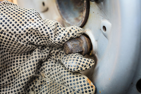 修理机械戴手套的男子更换和修理旧车轮图片