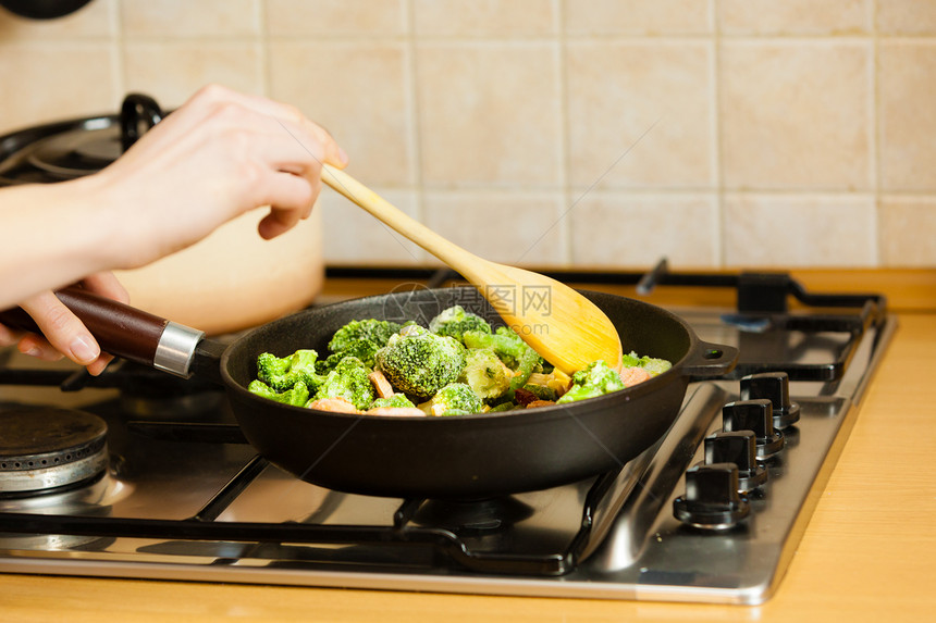 厨艺烹饪中的女子在锅上煎炒冷冻蔬菜在锅上煎煮美味的晚餐食图片
