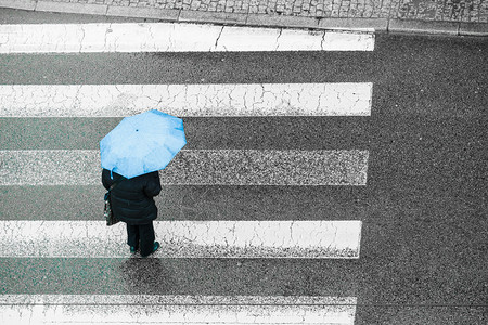 雨天时在城市街上行走的人拿着雨伞背景图片