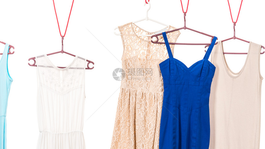许多彩色衣服蓝和奶油挂在衣柜架上白色背景彩衣服挂在架上图片