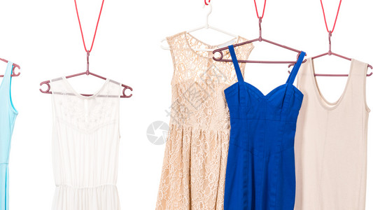 许多彩色衣服蓝和奶油挂在衣柜架上白色背景彩衣服挂在架上图片