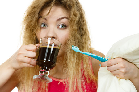 拿着牙刷喝完热饮后要刷牙的快乐女人拿着牙刷和咖啡的快乐女人图片