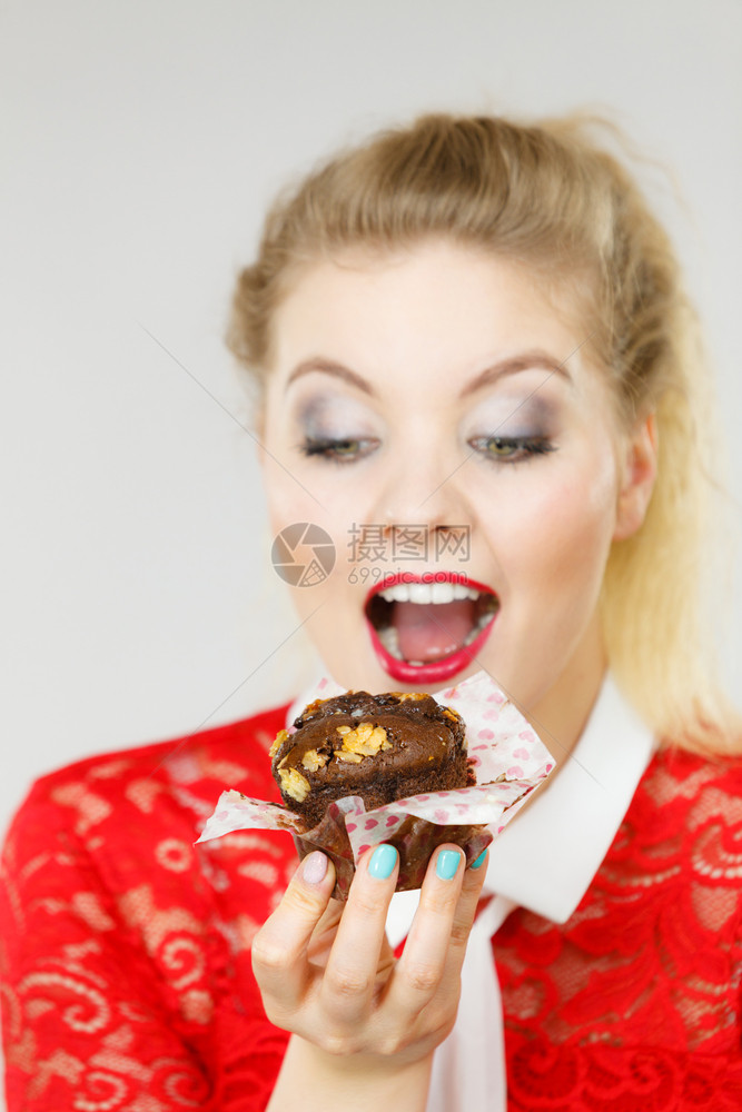 迷人的金发美女手握着味的巧克力蛋糕张开嘴渴望蛋糕图片