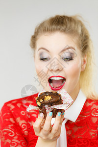 迷人的金发美女手握着味的巧克力蛋糕张开嘴渴望蛋糕图片
