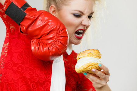 穿着拳击手套的女拿着甜点奶油蛋糕图片