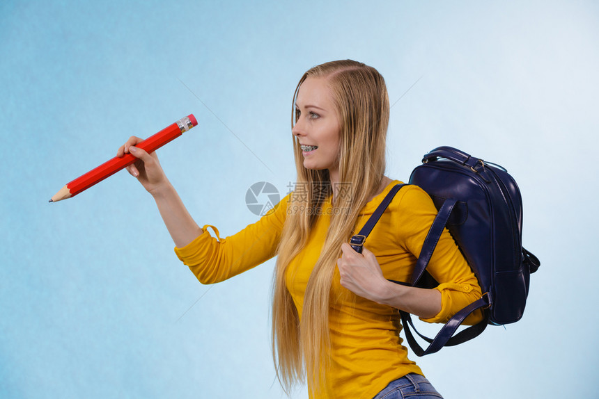 带着背包和拿大铅笔去上学或大的金发少女快乐的年轻金发女孩图片